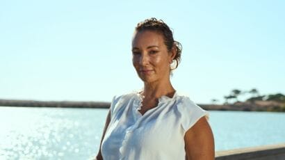 A woman by the waterfront highlighting Portugal's real estate opportunities with QMS, an advanced platform transforming property buying and selling in Portugal.