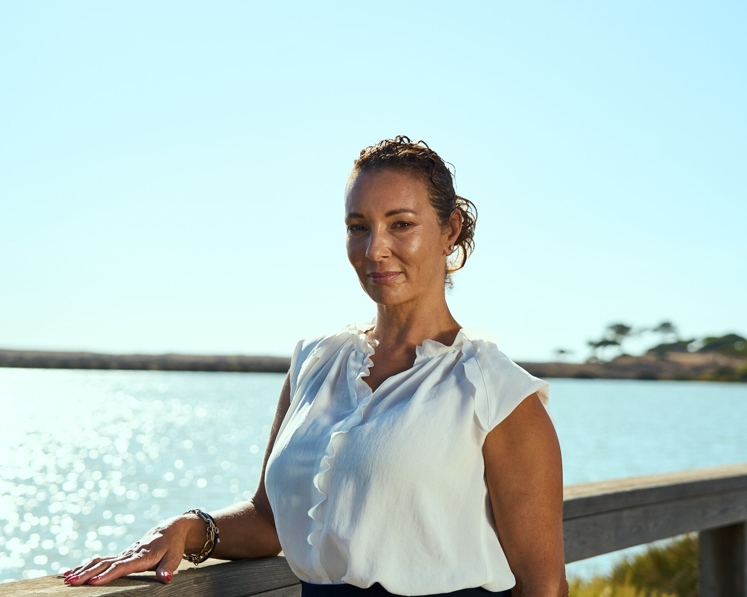 A woman by the waterfront highlighting Portugal's real estate opportunities with QMS, an advanced platform transforming property buying and selling in Portugal.